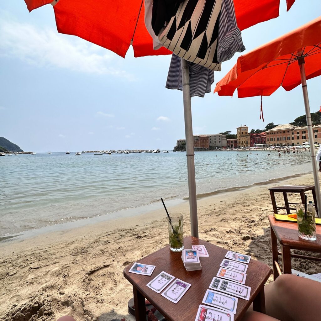 View of the beach from a lounger chair, with food and drink on the end table